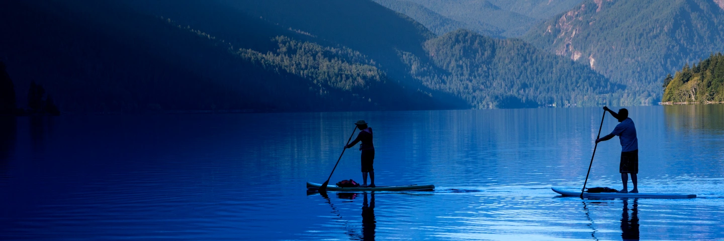 paddleboarders on serene blue lake